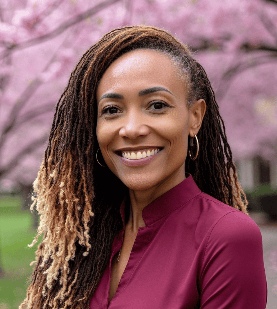 Constance Leger Headshot smiling in front of cherry blossom trees