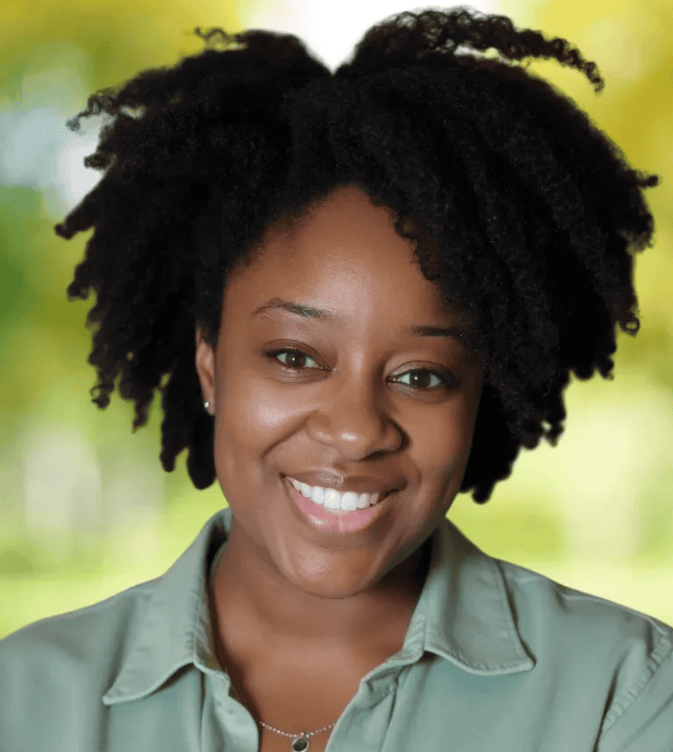 Quentina Johnson Headshot smiling in front of greenery