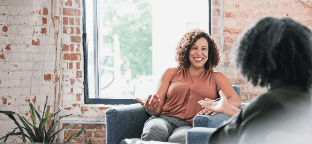 Therapist sitting with client while client smiles
