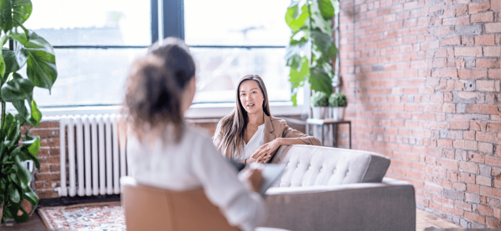 Therapist sitting with woman client while the woman talks. 