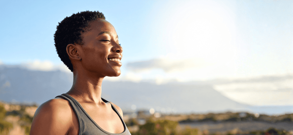 Woman smiling outdoors, conveying calm resilience